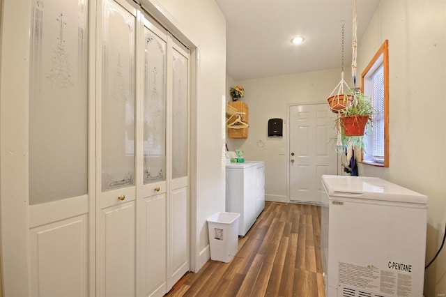 clothes washing area featuring laundry area, baseboards, independent washer and dryer, and dark wood-style flooring