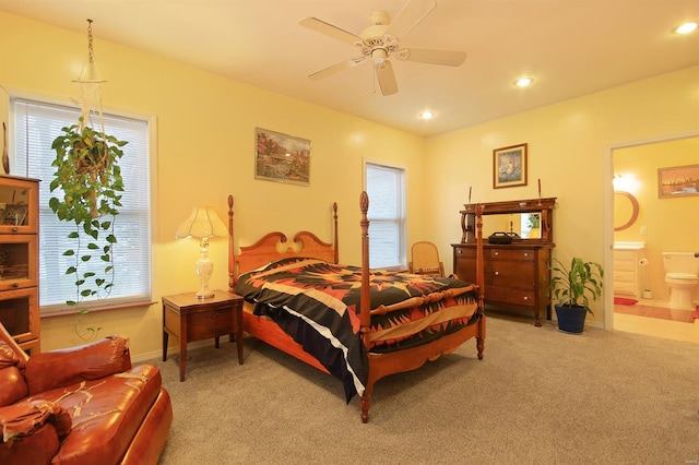 bedroom featuring multiple windows, recessed lighting, connected bathroom, and light carpet