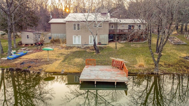 dock area with a lawn, a deck, and stairs