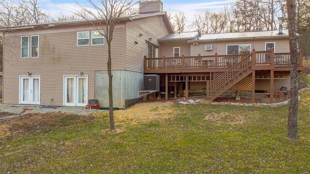 back of house featuring a wooden deck, a chimney, stairs, a lawn, and metal roof