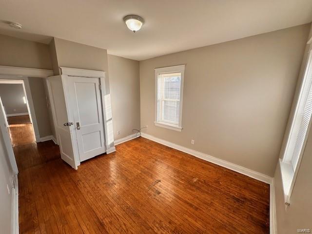 unfurnished bedroom with hardwood / wood-style floors and baseboards