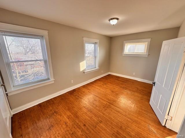 unfurnished bedroom with baseboards and light wood-style flooring