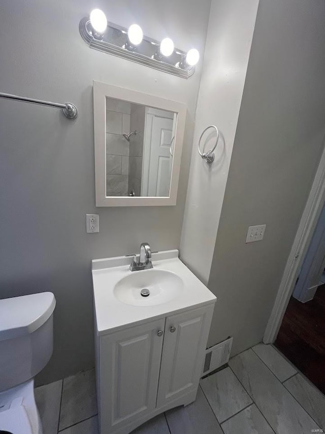 bathroom featuring visible vents, toilet, and vanity