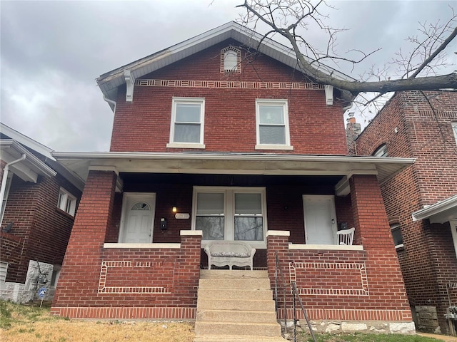 view of front of home featuring brick siding and a porch