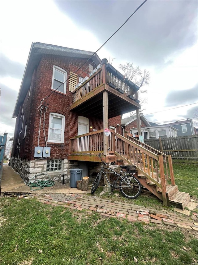 rear view of property with brick siding and fence