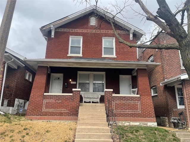 view of front facade with brick siding and covered porch