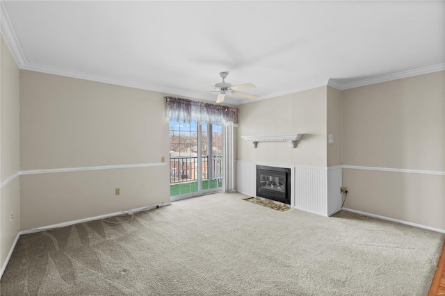 unfurnished living room with a ceiling fan, baseboards, carpet floors, a fireplace with flush hearth, and ornamental molding