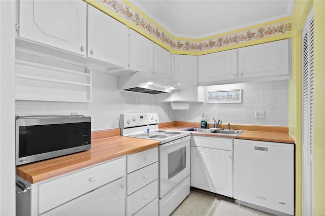 kitchen with white appliances, a sink, decorative backsplash, under cabinet range hood, and white cabinetry