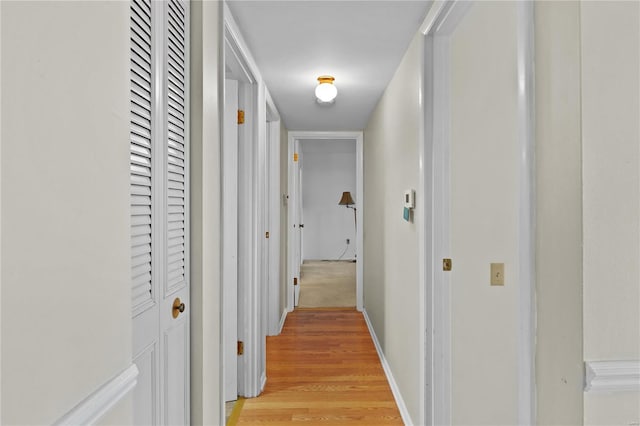 hallway with baseboards and light wood-style floors