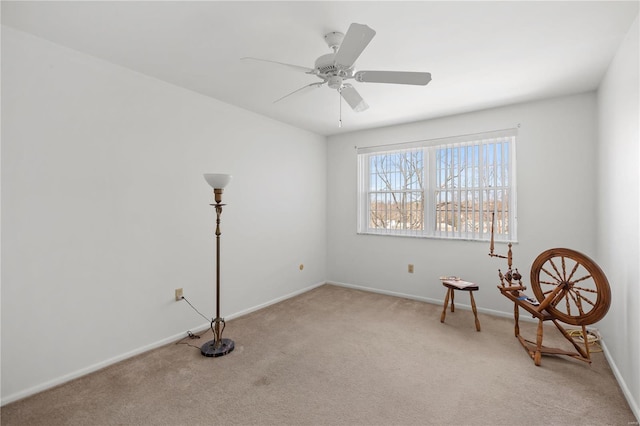 unfurnished room with a ceiling fan, baseboards, and light carpet