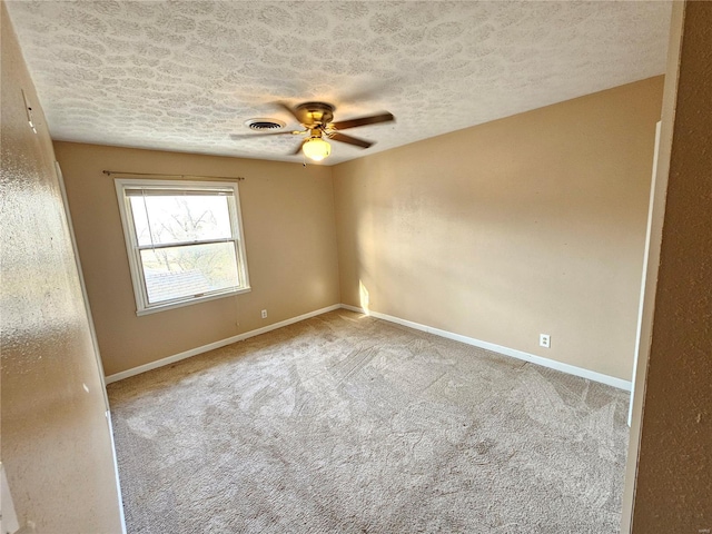 spare room with baseboards, carpet, ceiling fan, and a textured ceiling