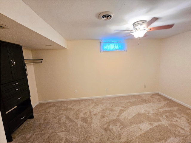 below grade area featuring visible vents, light carpet, and baseboards