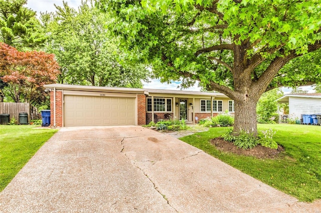 ranch-style home featuring brick siding, an attached garage, concrete driveway, and a front lawn