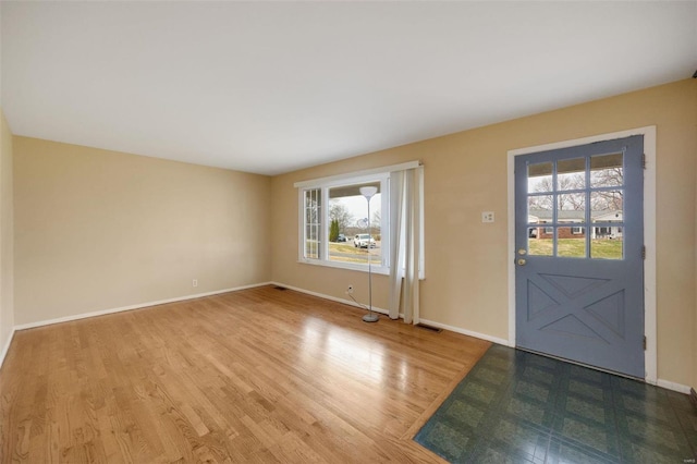 entryway featuring visible vents, baseboards, and wood finished floors