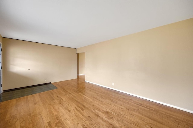 unfurnished room featuring baseboards and light wood-type flooring