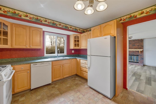 kitchen featuring white appliances, an inviting chandelier, a sink, glass insert cabinets, and dark countertops