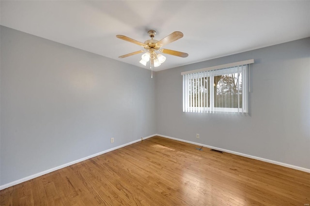 spare room featuring visible vents, baseboards, and wood finished floors