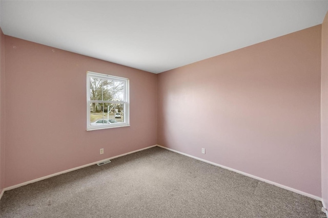 carpeted spare room with visible vents and baseboards