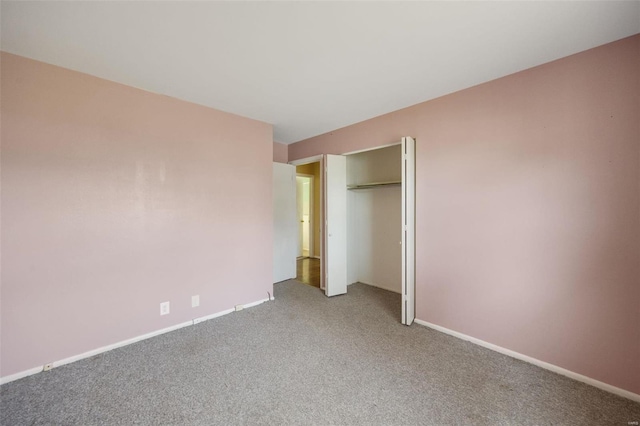 unfurnished bedroom featuring a closet, baseboards, and carpet floors