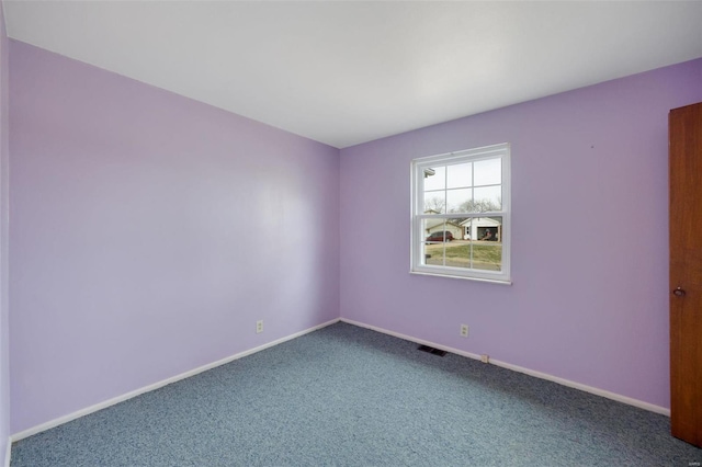 spare room featuring visible vents, baseboards, and carpet