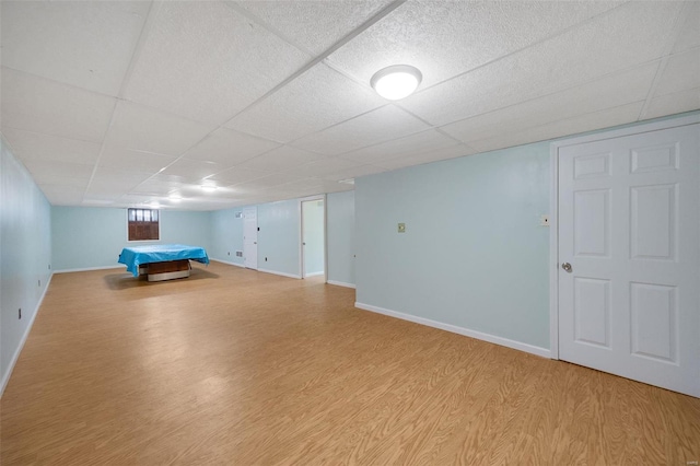 game room featuring a drop ceiling, baseboards, and wood finished floors