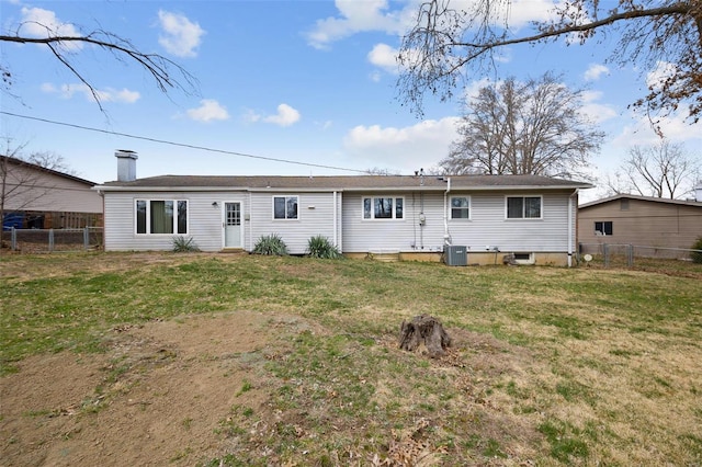 rear view of property featuring a lawn, central AC, a chimney, and fence