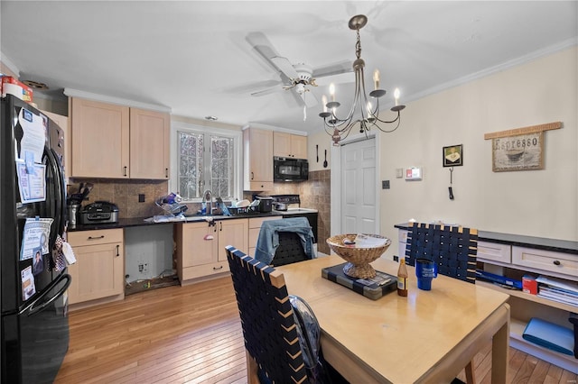 dining space with crown molding, ceiling fan with notable chandelier, and light wood-type flooring