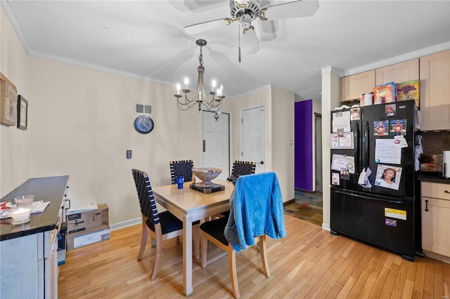 dining room with light wood-style flooring, visible vents, and ornamental molding