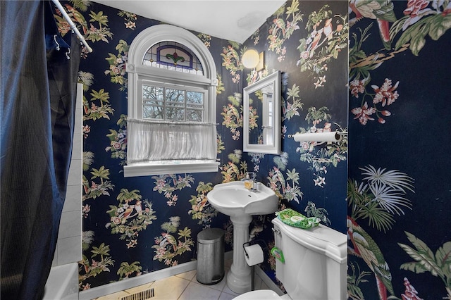 bathroom featuring tile patterned floors, visible vents, toilet, wallpapered walls, and baseboards