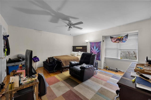 bedroom featuring ceiling fan, baseboards, and wood finished floors