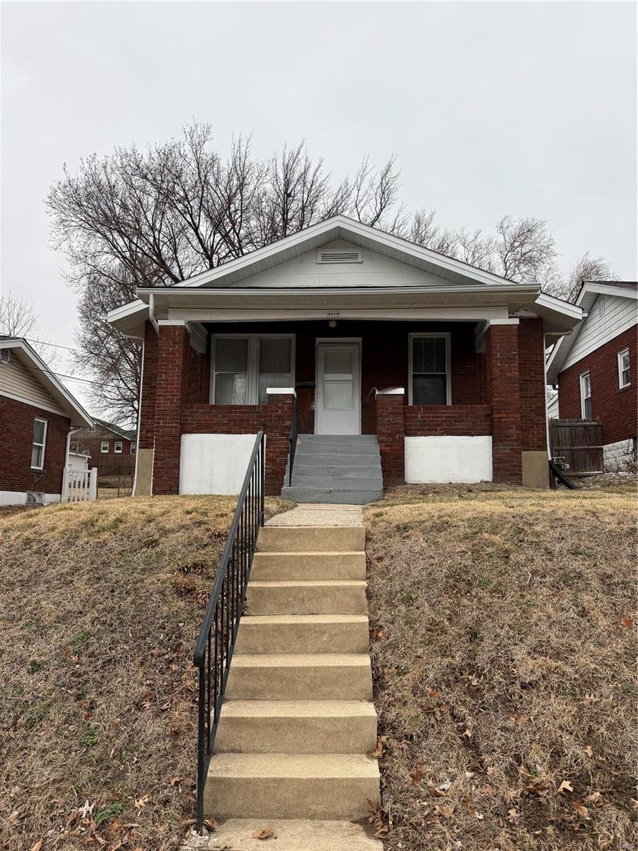 view of front of property featuring brick siding and covered porch