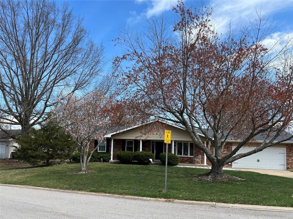 view of front facade featuring brick siding, an attached garage, driveway, and a front lawn