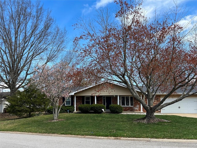 view of front of house featuring an attached garage, driveway, a front lawn, and brick siding