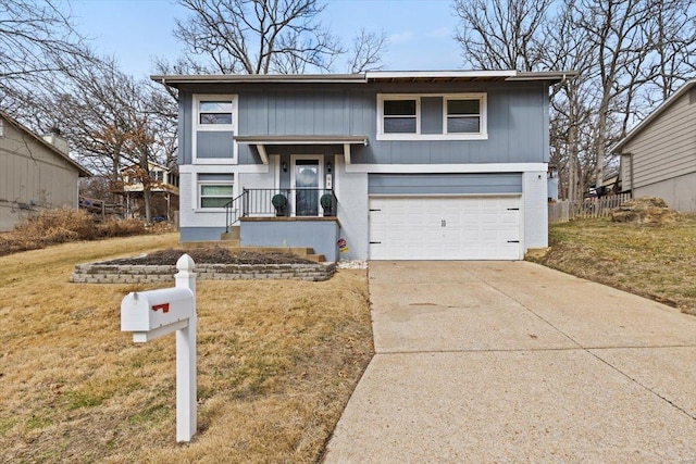 bi-level home featuring a garage, a front yard, and driveway