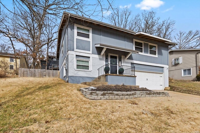 split foyer home with a garage, concrete driveway, a front yard, and fence