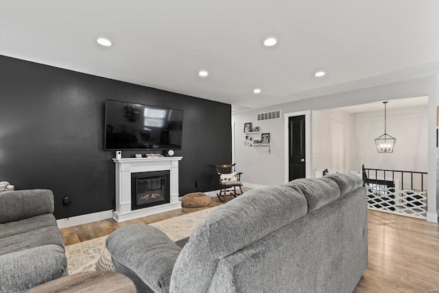 living area with a chandelier, visible vents, recessed lighting, and light wood-style floors