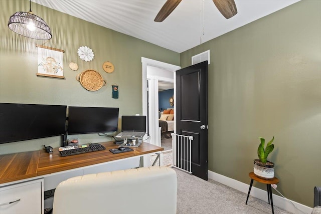 carpeted home office featuring visible vents, baseboards, and ceiling fan