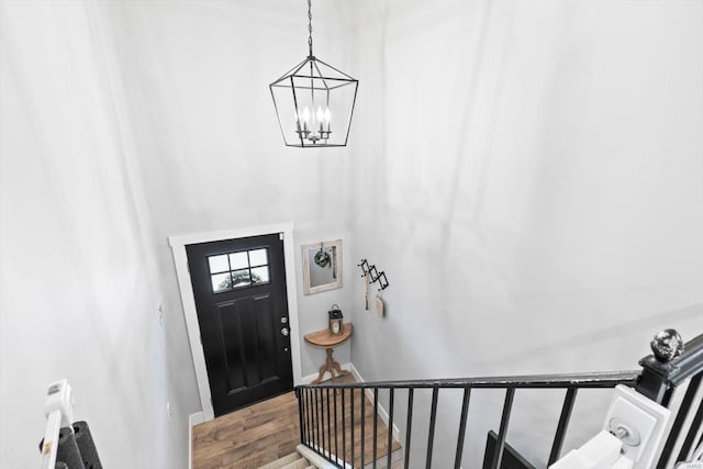 foyer featuring a notable chandelier, baseboards, and wood finished floors