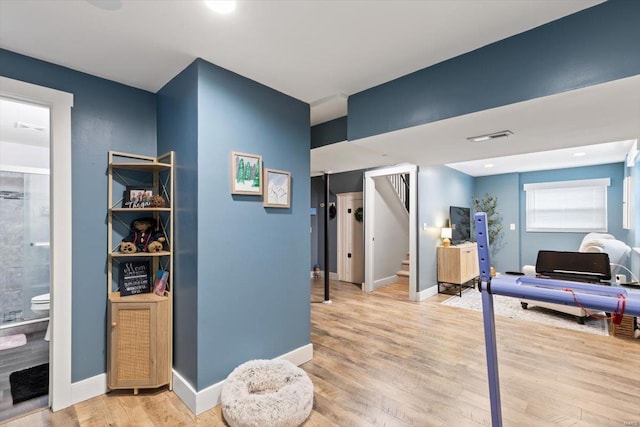 corridor featuring stairway, light wood-style floors, and baseboards