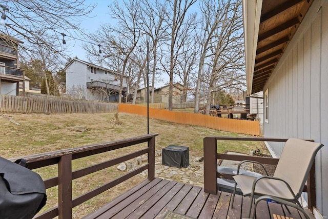 wooden terrace with a residential view, a lawn, and a fenced backyard