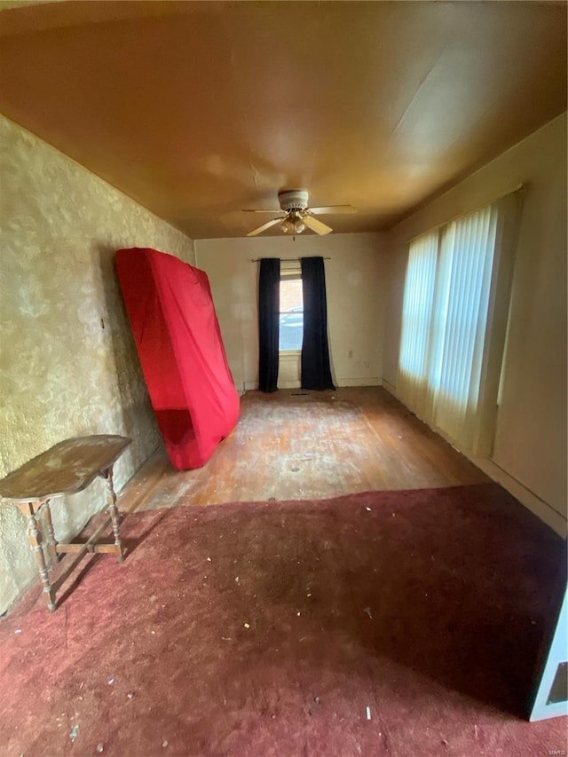 unfurnished living room featuring a ceiling fan