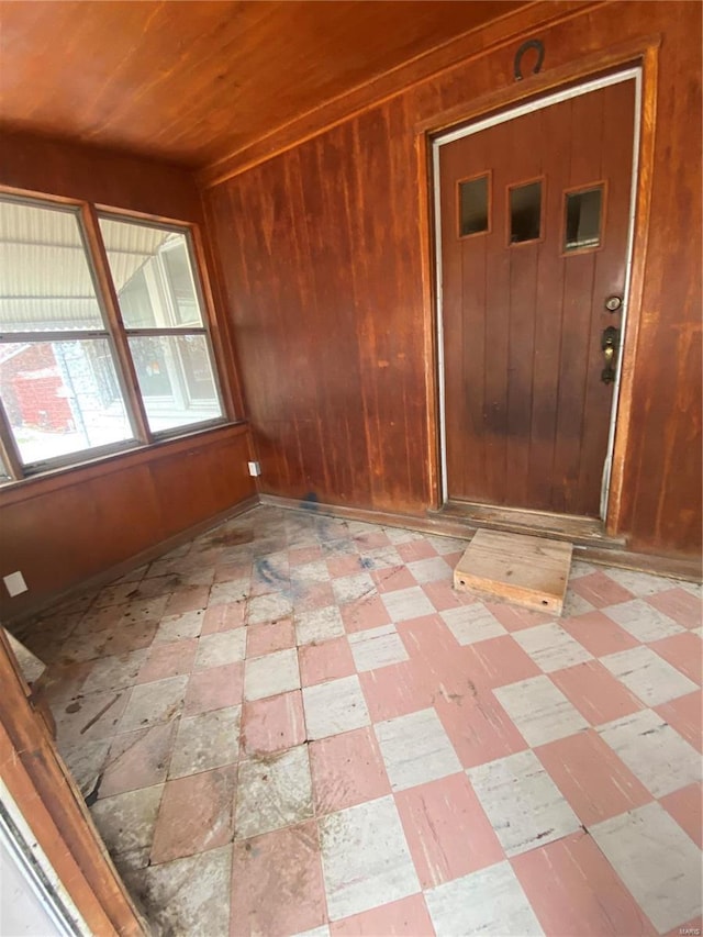 spare room with wood walls, wood ceiling, and light floors