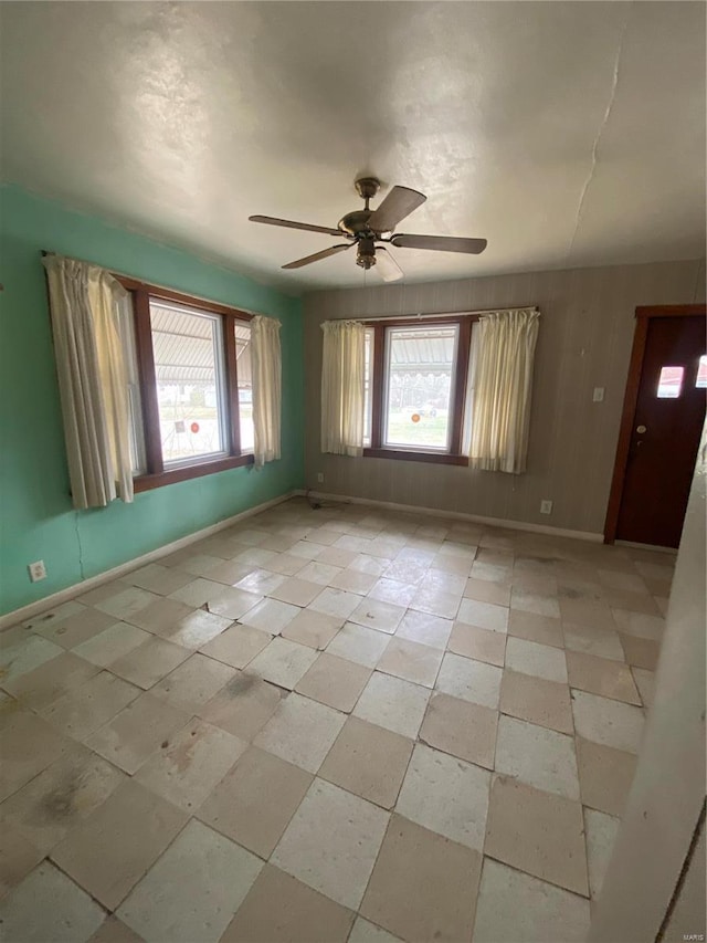 empty room featuring baseboards and ceiling fan