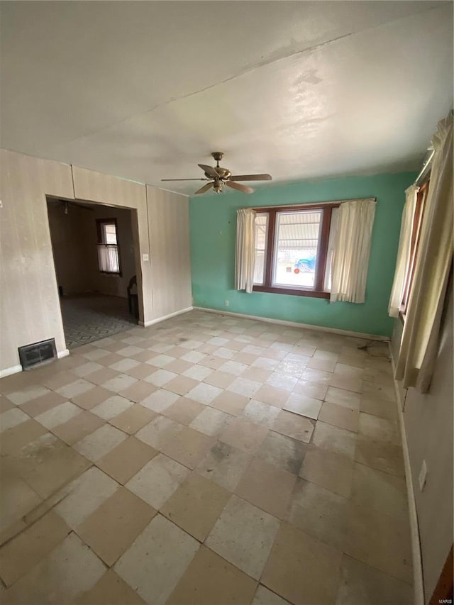 empty room with visible vents, baseboards, and a ceiling fan