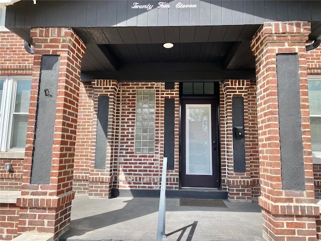 entrance to property featuring brick siding