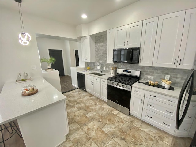 kitchen with light countertops, decorative backsplash, white cabinets, black appliances, and a sink