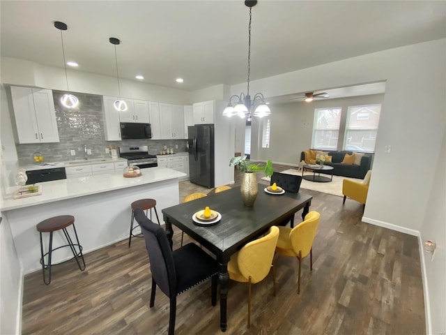 dining room featuring dark wood finished floors, recessed lighting, ceiling fan with notable chandelier, and baseboards
