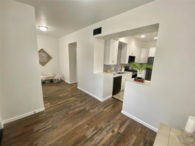 kitchen with light countertops, decorative backsplash, dark wood-style floors, white cabinets, and black appliances