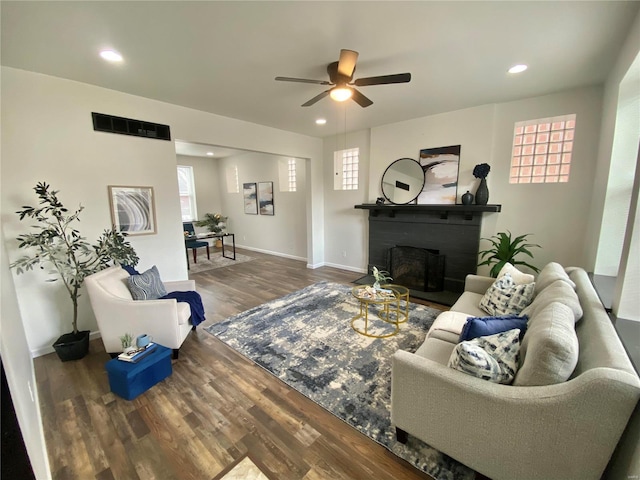 living room featuring wood finished floors, baseboards, recessed lighting, ceiling fan, and a brick fireplace