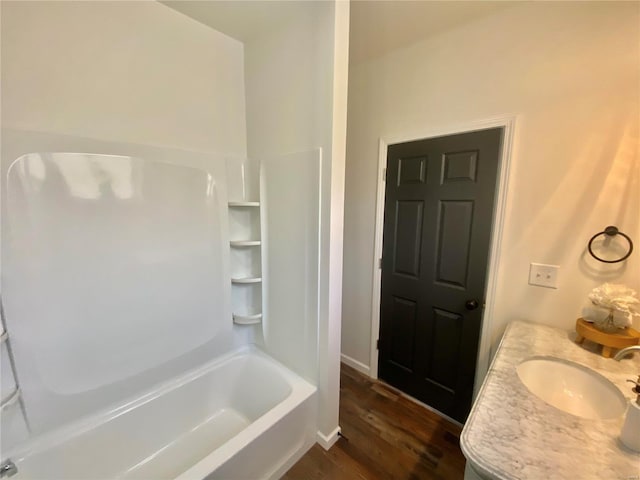 full bath featuring a sink, baseboards, wood finished floors, and bathtub / shower combination